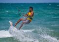 An adult kitesurfing on the ocean waves in Kalpitiya, Sri Lanka