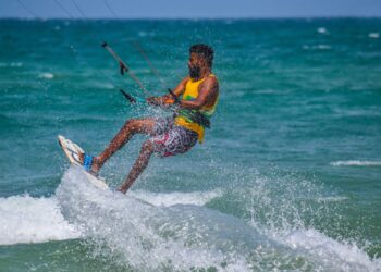 An adult kitesurfing on the ocean waves in Kalpitiya, Sri Lanka