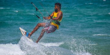 An adult kitesurfing on the ocean waves in Kalpitiya, Sri Lanka