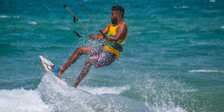 An adult kitesurfing on the ocean waves in Kalpitiya, Sri Lanka