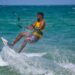 An adult kitesurfing on the ocean waves in Kalpitiya, Sri Lanka