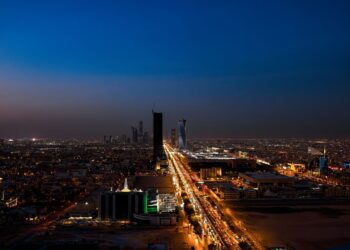 Dramatic aerial twilight view of Riyadh city skyline with lit streets