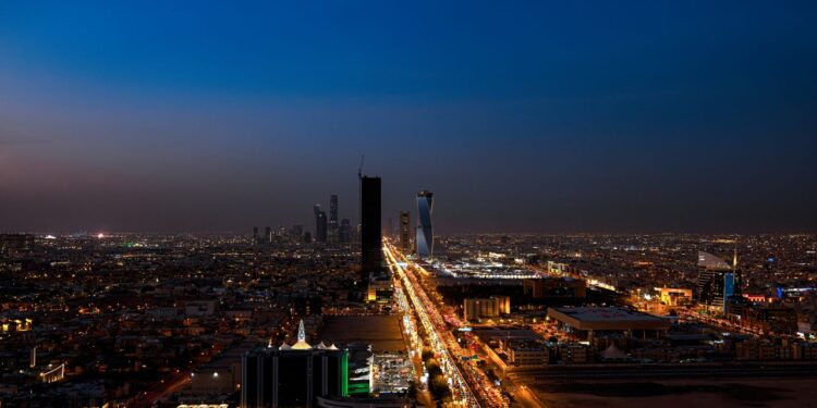 Dramatic aerial twilight view of Riyadh city skyline with lit streets